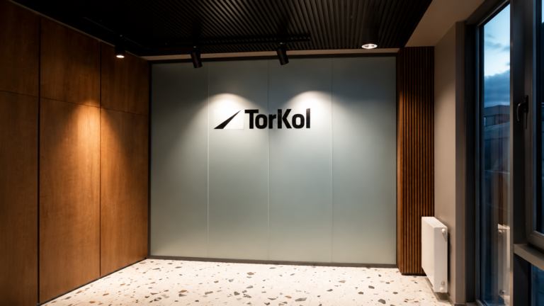 Folia mrożona na szklanej ścianie z wyciętym logo TorKol