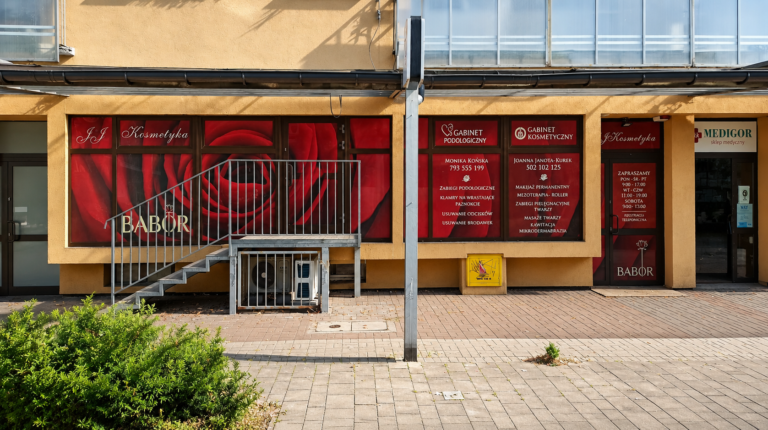 Witryna salonu kosmetycznego oklejona folią z czerwonym motywem róży